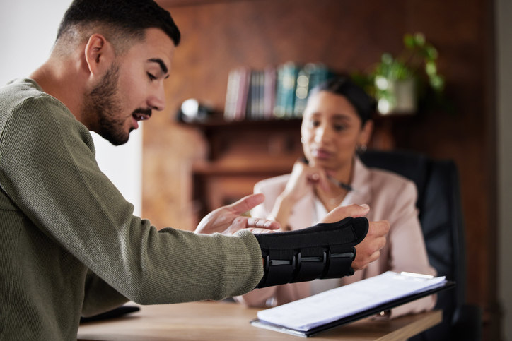 Legal labor law, injury or man with lawyer woman planning on documents for insurance, compliance and HR agreement. Consulting, advisor and male client for security claim or disability compensation