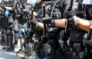 Police forming a line during a public disturbance.