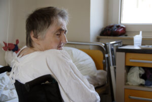 after leg broken- senior woman in wheelchair, in a room of a hospital