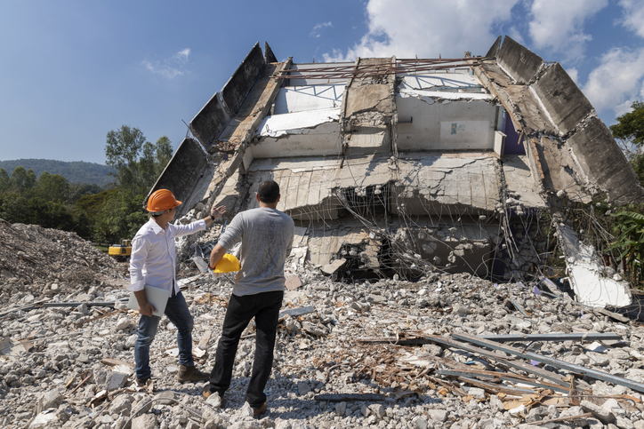 Demolition control supervisor and foreman discussing on demolish building.