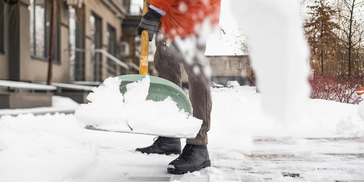 NYC homeowner clearing snow from sidewalk after winter storm